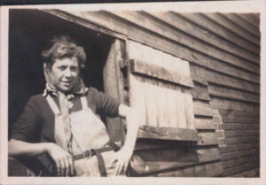 Joan Birchall in front of stables