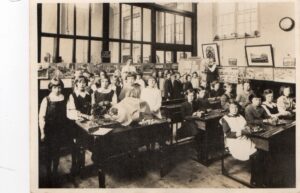 Joan and Geoff Shutte Archive Photo 23 Geoff: 'School room picture about 1933, or 1934. My mother is the 3rd from the left, standing behind the flower display. I am assuming the school room is in Dorchester, somewhere. Most likely in Coberg Road, Victoria Park, Dorchester, Dorset.'