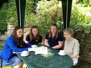 Cherish Watton showing an issue of The Landswoman to Valerie Linder and her granddaughters.