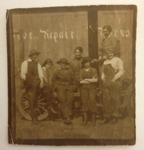 Phyllis Sahmer (nee Drayton) in front (second right) of the Tractor and/or Motor Repair Works. She stands with her arms folded in the front row