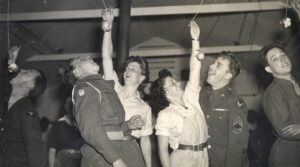 Caption: Ann Brodrick (left) with British serviceman and Mary Codrington with an American serviceman at a Halloween party c.1943 in Milton Ernest WLA hutment hostel, Bedfordshire.