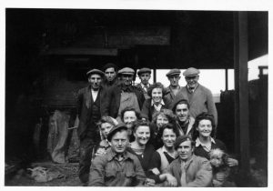 Group photo of farmers, Land Girls and two POWS on the front row