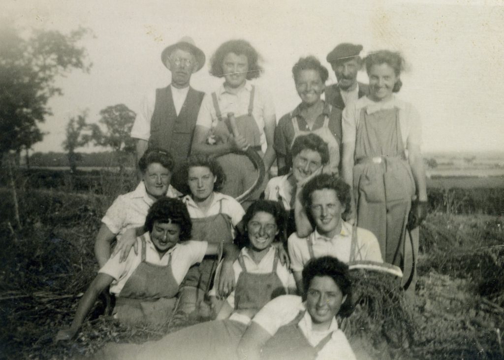 Iris is in the back row, second from left, holding a scythe, Evelyn is in the second row right hand side holding a scythe.