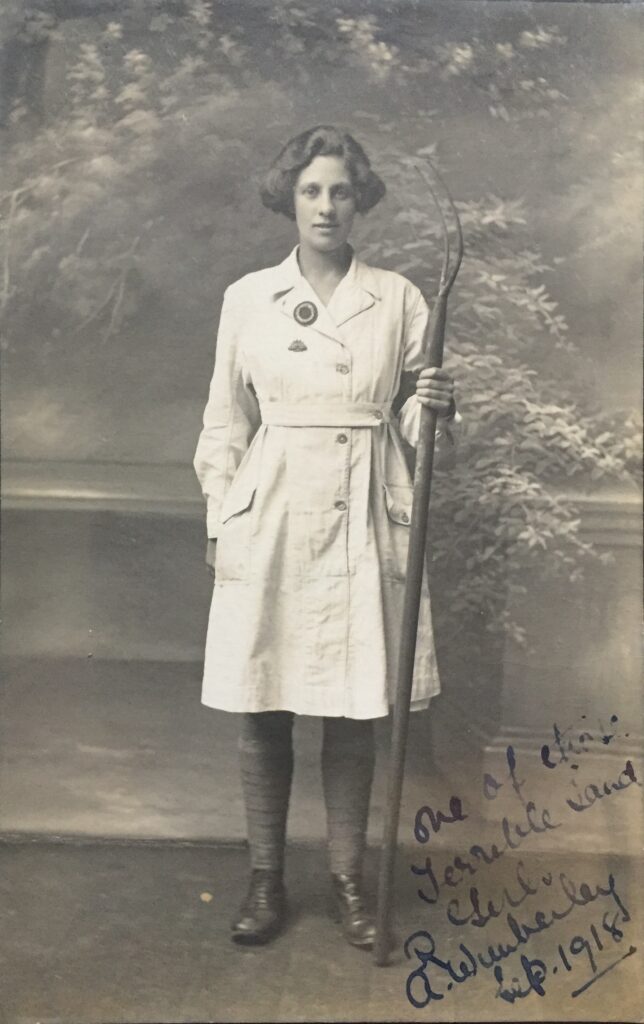 A First World War Land Girl holding a pitchfork.